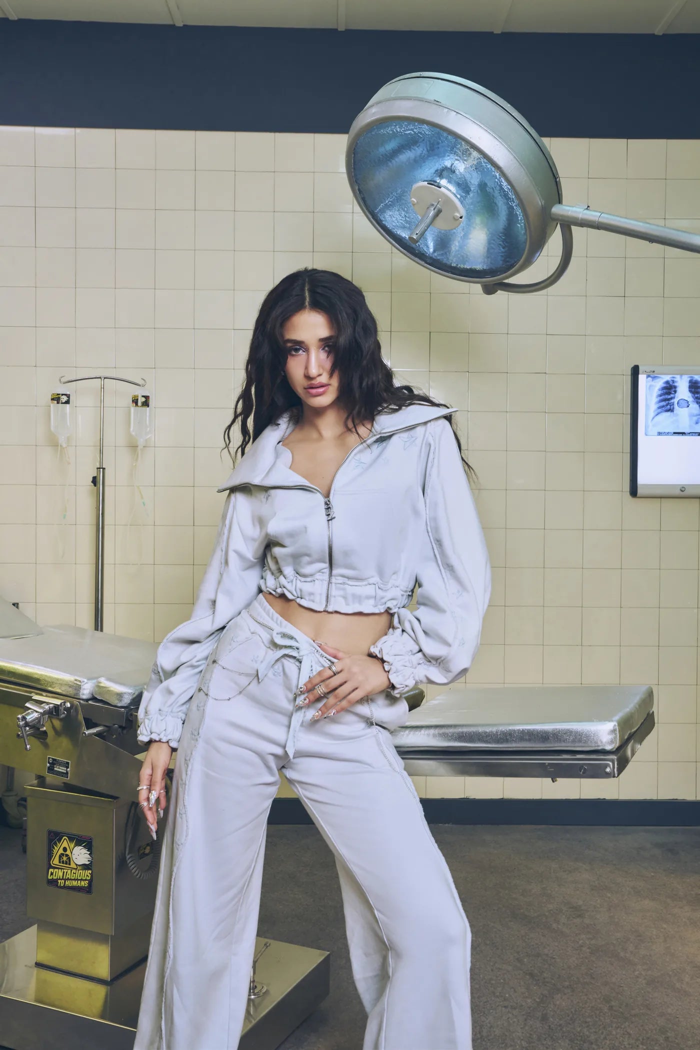 Disha in the light grey DZ set in a clinic, under the surgery lamp